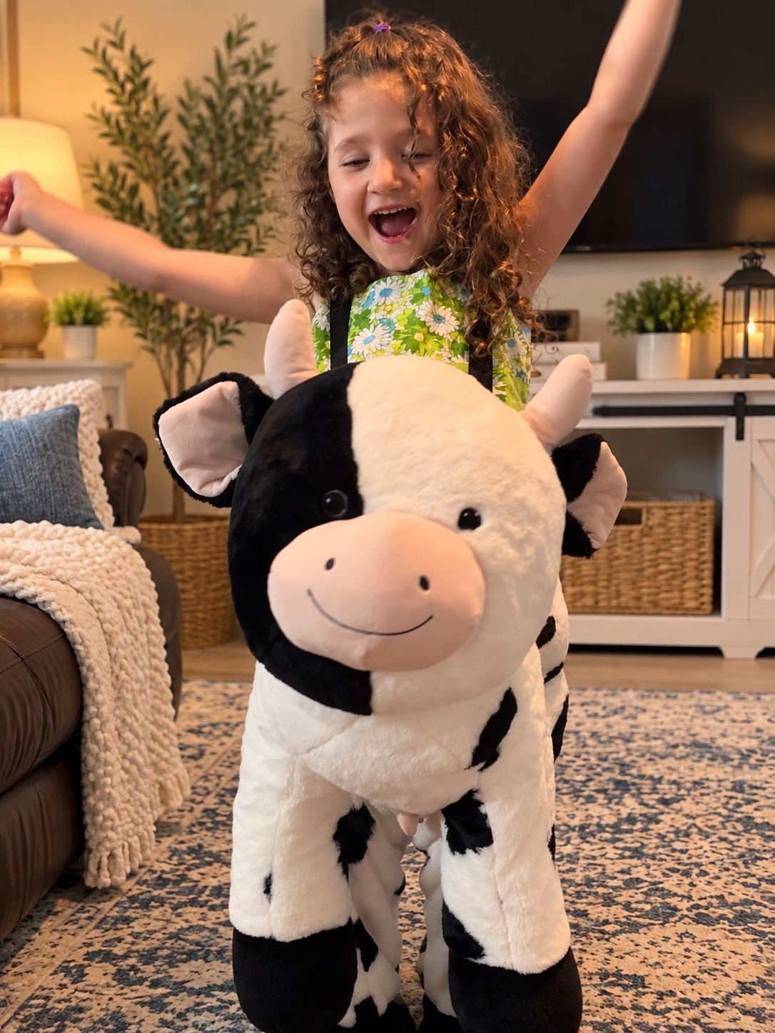 Isabella playing with a large plush cow at home